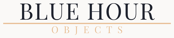 A logo or brand graphic reading 'BLUE HOUR' in large dark navy text, with 'OBJECTS' in smaller tan text below a thin tan horizontal line on an off-white background.